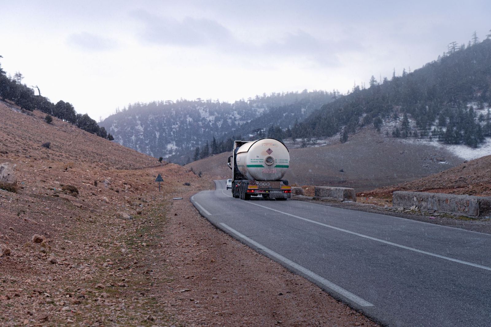 Tanker truck on a winter highway with snowy hills
